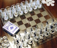 a chess board with cups and coins on it