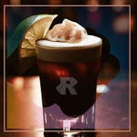 an irish coffee with whipped cream and a lime wedge